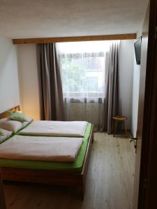 ein Schlafzimmer mit einem Bett und einem großen Fenster in der Unterkunft Birkenhof in Ehrwald