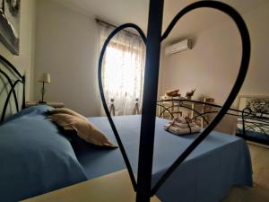 a bedroom with a bed with a heart shaped frame at B&B Alghero Mare Chiaro in Alghero