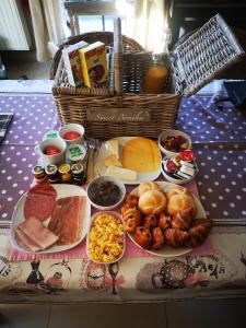 una mesa cubierta con platos de comida y una cesta de comida en Wellness Sweet Bonihu B&B en Brujas