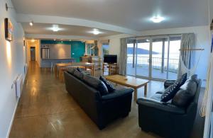 a living room with two couches and a table at Mukies Apartments in Ahipara