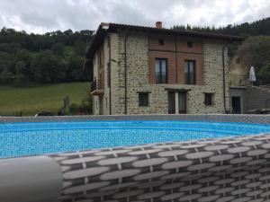 a large swimming pool in front of a house at ETXEARTZI in Arciniega