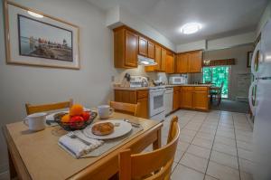 a kitchen with a table with a bowl of fruit on it at Brewster Green Resort in Brewster