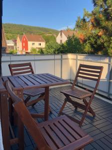 2 sillas y una mesa de madera y sillas en un patio en Ferienwohnung ANHAUS, en Coblenza