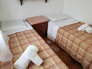 dos camas sentadas una al lado de la otra en una habitación en Vosso Lar com Vista Gramado, en Gramado
