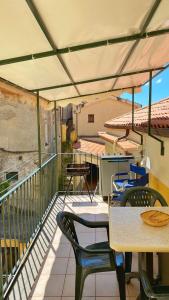 a patio with tables and chairs on a balcony at Casa Santicelli Maratea “ Il Campanile” in Maratea