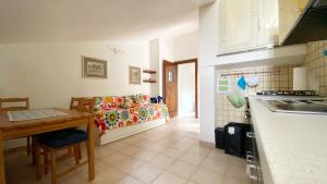 a kitchen and a living room with a couch and a table at Casa Santicelli Maratea “ Il Campanile” in Maratea +2 photos