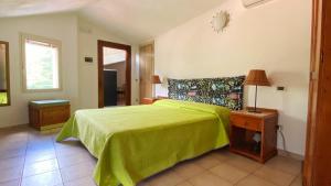 a bedroom with a bed with a green bedspread at Casa Santicelli Maratea “ Il Campanile” in Maratea