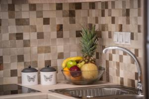 a basket of fruit sitting on a counter next to a sink at Bounatsa Studios & Apartments in Nydri