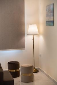 奈德里的住宿－Bounatsa Studios & Apartments，一间带灯和两张凳子的客厅