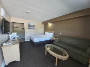 una camera d'albergo con letto e divano di Arnprior Motor Inn ad Arnprior