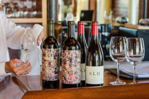 drie flessen wijn zittend op een tafel met wijnglazen bij The Sullivan House in New Shoreham
