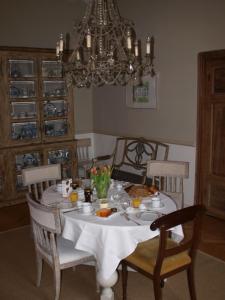 einen Esstisch mit Essen und einen Kronleuchter in der Unterkunft Buitenplaats Bemelen in Bemelen