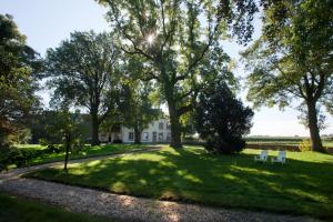 twee witte banken in het gras voor een huis bij Buitenplaats Bemelen in Bemelen