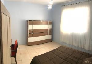 1 dormitorio con cama y ventana en Apto NOVO, totalmente equipado e bem localizado, en Bento Gonçalves