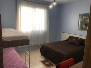 1 dormitorio con 2 camas y ventana en Apto NOVO, totalmente equipado e bem localizado, en Bento Gonçalves