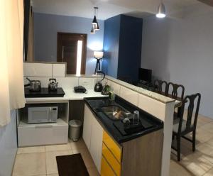 a kitchen with a sink and a counter top at APTO completo, aconchegante e bem localizado in Bento Gonçalves +2 photos