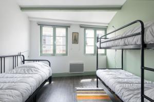 サン・マルタン・ド・レにあるAppartement Bastingageの緑の壁のドミトリールームの二段ベッド2台
