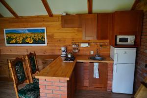a kitchen with a white refrigerator and a sink at Agroturystyka Witoldówka in Perlejewo