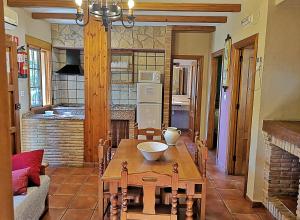 sala de estar con mesa y cocina en Casa Laguna del Maiz cazorla, en Burunchel