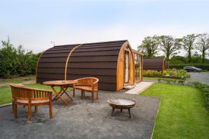 a circular building with a table and chairs in a yard at Orchard Glamping in Catterall