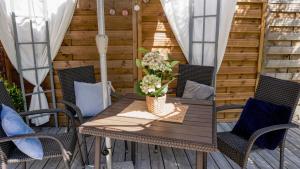 una mesa de madera y sillas en un patio en Apartament Malwa, en Sopot