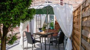 un patio con mesa y sillas bajo una sombrilla en Apartament Malwa, en Sopot