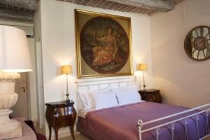 a bedroom with a bed with a painting on the wall at Le Stanze del Cardinale in Pavia