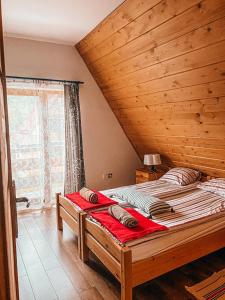 a large bed in a room with a wooden ceiling at Urocze domki Zakopane in Zakopane