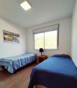 ein Schlafzimmer mit zwei Betten und einem Fenster in der Unterkunft Marine Home Resort- piscina aquecida-hidromassagem in Florianópolis