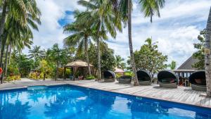 - une piscine dans un complexe avec des palmiers dans l'établissement Octopus Resort, à Nalauwaki