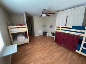 a room with two bunk beds and a ceiling fan at WHOLE Family - Barrette in Sacramento