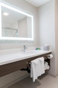 a bathroom with a sink and a mirror and towels at Holiday Inn Express San Clemente N – Beach Area, an IHG Hotel in San Clemente