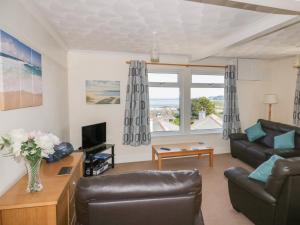 a living room with a couch and a tv at Yellow Sands Apartment 7 in Padstow