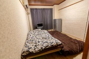 a small room with a bed and a television at Chiba Breen hills Inage #8Mx in Chiba
