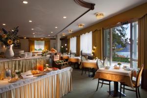 un restaurante con mesas y sillas con comida. en Hotel Miralago Wellness - Adults Only, en Molveno