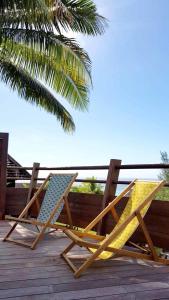 twee stoelen op een terras met een palmboom bij Villa Anuanua by Tahiti Homes in Papetoai