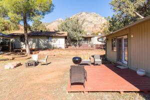 a wooden deck with chairs and a house at Spacious house with hot tub spa, to enjoy red rock view, near Amitabha stupa, and trails in Sedona