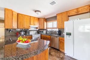 a kitchen with wooden cabinets and a bowl of fruit on the counter at Spacious house with hot tub spa, to enjoy red rock view, near Amitabha stupa, and trails in Sedona