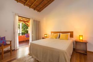 a bedroom with a bed with yellow pillows at Charm Bahia Residencias in Arraial d'Ajuda