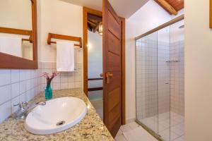 a bathroom with a sink and a shower at Charm Bahia Residencias in Arraial d'Ajuda