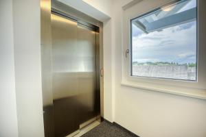 La salle de bains est pourvue d'une porte en verre et d'une fenêtre. dans l'établissement Ferienwohnungen Petschnig 1, à Drobollach am Faakersee