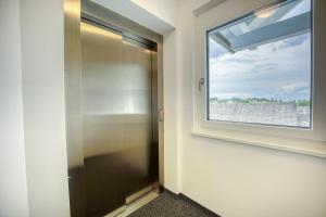 a bathroom with a glass door and a window at Ferienwohnungen Petschnig 1 in Drobollach am Faaker See