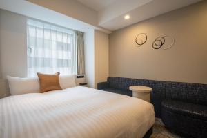 a hotel room with a bed and a couch at Hotel Vista Tokyo Tsukiji in Tokyo