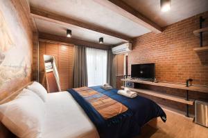 大城的住宿－Sri Ayutthaya，一间卧室设有一张大床和砖墙