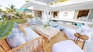 un patio con mesa, sillas y piscina en Sunyi Villas en Kuta Lombok