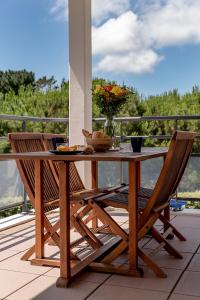 a wooden table with two chairs and a vase of flowers at Spacieux T2 remis à neuf, à 3 min des plages, terrasse in Anglet