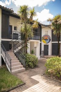 a building with stairs and palm trees in front of it at Spacieux T2 remis à neuf, à 3 min des plages, terrasse in Anglet
