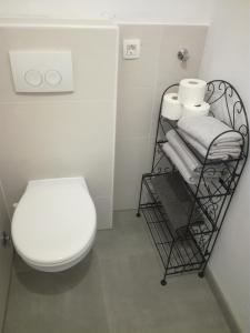 a bathroom with a toilet and a rack with towels at Apartment Mila Krk in Krk
