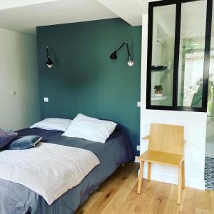 sypialnia z łóżkiem, lustrem i krzesłem w obiekcie Cocon en lisière de forêt w mieście Bourron-Marlotte
