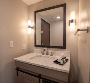 a bathroom with a sink and a large mirror at Superior Stay Hotel in Marquette